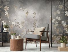 a chair and table in front of a wallpapered room with flowers on it