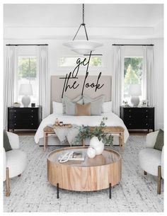 a bedroom with white walls and wood furniture in the center, along with an oversized round coffee table