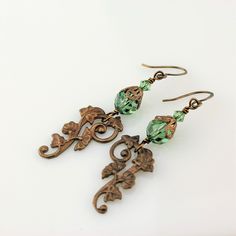 "An adorable new pair of crystal earrings with Swarovski crystals in a pretty pale emerald green, with a brass component with a gingko and ivy leaf pattern. These have a Victorian feel and are very lightweight! These one of a kind earrings measure 2 1/4\" and will arrive beautifully packaged. To see more jewelry and handmade beads, click here: https://www.etsy.com/shop/StoneDesignsbySheila?ref=hdr_shop_menu" Handmade Green Crystal Metal Earrings, Green Crystal Earrings For Jewelry Making, Vintage Green Czech Glass Earrings, Elegant Green Copper Earrings, Lampwork Bead Earrings, Green Antique, Classy Earrings, Lampwork Earring, Ivy Leaf