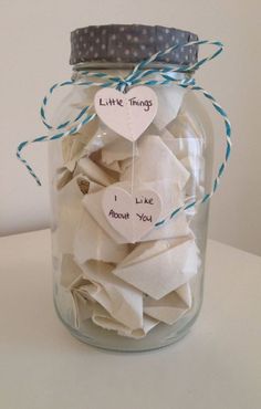 a glass jar filled with white paper hearts