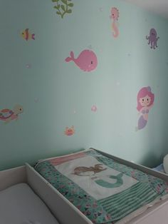 a baby's room with a crib and wall decals on the walls