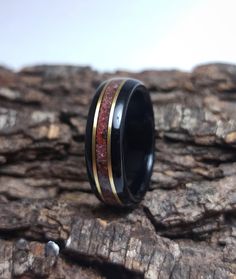 "African Ebony wood ring with a centered band of crushed Garnet gemstone and Bronze inlays. * Made to order in all sizes. * Finished first with tung oil to really bring out the wood grains beauty, then coated with multiple layers of CA achieving a strong high-gloss polish * Extremely durable and water resistant. * Fast worldwide shipping *Shipping* This item includes free domestic and international shipping. Its delivery process takes from 10 to 15 business days and it includes a track & tra Spiritual Black Jewelry For Promise, Black Inlay Jewelry As A Gift, Black Jewelry With Inlay For Gift, Handmade Black Promise Ring, Handmade Black Jewelry For Promise, Handmade Black Promise Jewelry, Black Handmade Promise Jewelry, Black Ring With Inlay, Black Rings With Inlay