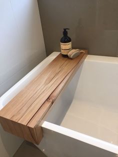 a wooden shelf sitting on top of a bath tub