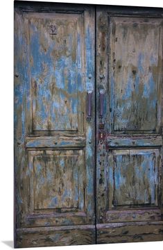 an old wooden door with peeling paint on the doors and bottom part of it painted blue