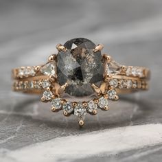 an engagement ring with a large gray diamond surrounded by smaller white and yellow diamonds on top