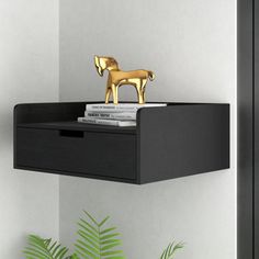 a gold horse figurine sitting on top of a shelf next to a potted plant