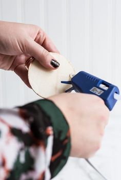 a person using a pair of scissors to cut wood