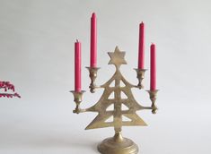 a brass candelabra with five candles in the shape of a christmas tree