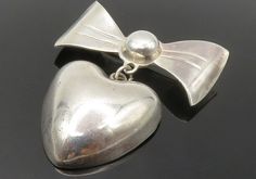 "MEXICO 925 Sterling Silver - Vintage Love Heart Ribbon Bow Brooch Pin - BP5465  MEXICO 925 Sterling Silver - Vintage Love Heart Ribbon Bow Brooch Pin - BP5465  Jewelry Type:         Brooch Pin   Metal Type:            925 Silver  Metal Size:             1.5\"  Stone Type:            N/A  Condition:              N/A  Jewelry Weight:     9.3 Grams  PLEASE NOTE: THIS ITEM IS PRE-OWNED. ALTHOUGH MOST ITEMS ARE IN VERY GOOD CONDITION, SOME MAY NEED CLEANING AND/OR MINOR REPAIRS. WE MAKE A VERY STRONG EFFORT TO UPLOAD CLEAR PICTURES. PLEASE INSPECT ALL PICTURES AND ASK ALL QUESTIONS YOU MAY HAVE PRIOR TO MAKING A PURCHASE. NOT ALL STONES ARE GENUINE, SOME ARE ENHANCED OR CREATED." Silver Heart Brooch For Valentine's Day, Silver Heart-shaped Brooch For Valentine's Day, Valentine's Day Silver Heart Brooch, Silver Heart Brooches For Gift, Silver Brooches For Anniversary On Valentine's Day, Vintage Silver Brooches For Valentine's Day, Heart Ribbon, Clear Pictures, Bow Brooch