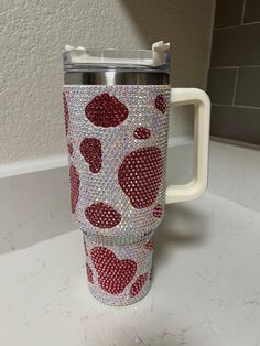 a red and white coffee cup sitting on top of a counter next to a wall