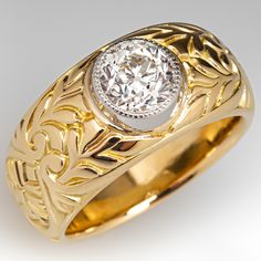 a gold ring with a diamond in the center and an intricate design on the band