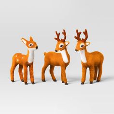 three toy deer standing next to each other