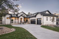 a large white house with black garage doors