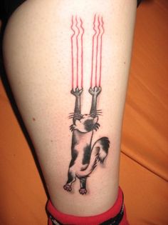 a person with a cat tattoo on their leg holding two red candles in the air