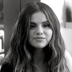 a black and white photo of a woman with long hair looking off to the side