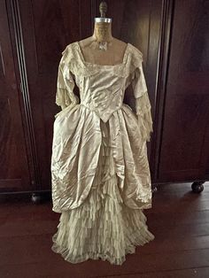 Stunning and very rare Georgian/Victorian Authentic Silk & Tule Antique Ball Gown. Champagne/Ivory in color, damask pink, this dress is from 1830's-1870's or earlier. It has a gorgeous cascade of tule/lace down the front of the dress and arms. Beautiful example of an elegant gown from its time.  There are three small tears on on the back of the dress and two under one of the arms.  It could be fixed by a professional but otherwise the dress is in excellent shape considering the very old age. The Elegant Beige Costume Dress, Elegant Historical Gown For Fancy Dress, Elegant Gown With Historical Design For Fancy Dress, Elegant Historical Design Gown For Fancy Dress, Victorian Floor-length Dress With Historical Design, Vintage Gown With Ruffles For Fancy Dress, Vintage Ruffled Gown For Fancy Dress, Formal Victorian Floor-length Dress With Historical Design, Formal Floor-length Victorian Dress With Historical Design