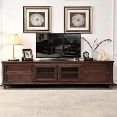 an entertainment center with two framed pictures on the wall