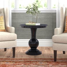 two chairs sitting next to each other near a table with a potted plant on it