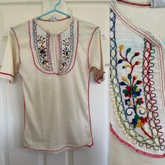 Vintage 70s ivory t shirt with multi colored embroidery at chest and red serging detail throughout.  Slightly sheer.  Made by Topjons, 100% acrylic.  Perfect condition, looks never worn. Vintage size M.  Measurements suggest size S.  May also work for larger sizes because of the stretch, and depending on desired fit.  Please check measurements and compare to a garment in your closet with your desired fit. Length 25.5 Shoulders 15" PTP 16" (32" chest) Waist 15" (30") Hip 15.5" (31") Sleeve length 9.5" Not responsible for lost or damaged packages, or customs fees.  Please see shop policies for additional information. Retro Short Sleeve Top With Floral Embroidery, Vintage Red Tops With Floral Embroidery, Red Vintage Tops With Floral Embroidery, Traditional Cream Tops For Summer, Traditional Cream Summer Top, Vintage Short Sleeve Cream T-shirt, Vintage Cream Short-sleeved T-shirt, Vintage Cream T-shirt For Summer, Vintage Embroidered Beige Tops