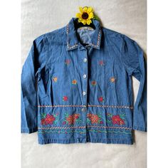 This vintage Bobbie Brooks denim jacket features vibrant embroidered floral patterns. Crafted from 100% cotton, it offers a unique, timeless style. * Button closure * Colorful floral embroidery * Long sleeves * Denim material * Made in Bangladesh * Exclusive of trimming Pit to pit = 21.5 inches Top to bottom = 24.5 inches Sleeve length = 17 inches Long Sleeve Cotton Denim Jacket With Floral Print, Retro Embroidered Cotton Outerwear, Retro Cotton Outerwear With Embroidery, Embroidered Denim Button-up Jacket For Spring, Embroidered Button-up Denim Jacket For Spring, Embroidered Cotton Denim Jacket For Fall, Bohemian Cotton Denim Jacket With Floral Embroidery, Vintage Long Sleeve Denim Jacket For Spring, Bohemian Denim Jacket With Floral Embroidery