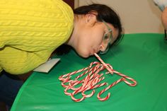 a woman blowing out candy canes on top of a green table