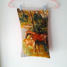 a pillow hanging on a clothes line with horses