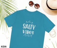 Salty Vibes ~ This beach shirt is fun and unique! It would be a perfect beach vacation shirt or a gift for anyone who loves the ocean or beach! We are so happy you found our shop! See our other listings for more colors and designs. Please reach out if you're looking for something specific that we don't currently offer. ✨Product Details✨ Our shirts are Bella + Canvas 3001 Adult Unisex Short Sleeve Tee Features: ーLight, breathable, soft fabric + quality print ーDual side seams for durability ーRibbe Beachy Vacation Shirt, Fun Beach Vacation Tops, Fun Vacation Top For Beach Season, Fun Beach Season Vacation Top, Fun Beach Tops For Vacation, Trendy Beach Vacation Shirt, Fun Top For Vacation And Beach Season, Fun Vacation Shirt With Letter Print, Beachy Shirt For Beach Party