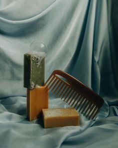 two soap bars and a comb on a blue cloth