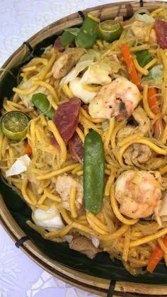 a plate full of noodles with shrimp, peppers and other toppings on the side