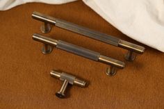 three antique style handles on a brown surface