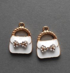 pair of white and gold tone earrings with bow