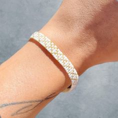 Simple and elegant gold and white seed bead bracelet. Elegant Gold Friendship Bracelets With Gold Beads, Everyday White Beaded Bangle Bracelet, Handmade White Braided Bracelets For Everyday, Handmade White Friendship Bracelets For Everyday, Everyday Handmade White Friendship Bracelets, Elegant White Pearl Bracelet With Tiny Beads, White Tiny Beads Friendship Bracelet, Everyday White Beaded Jewelry, Gold Beaded Minimalist Braided Bracelet