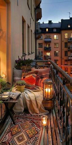 a balcony with candles and pillows on it