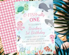 an ocean themed birthday party with pink and blue gingham table cloth, fishy one to celebrate burle's 1st birthday