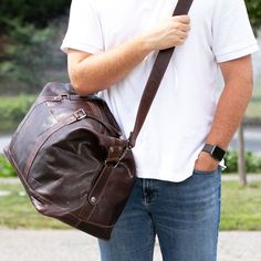 FREE GROUND SHIPPING & FREE MONOGRAMMING! HAND-STAINED BUFFALO LEATHER Pack your gear and essentials for the day or for a longer trip in the Voyager Duffle Bag. Made from hand-stained buffalo leather, this bag will build a rich, luxurious patina as it ages. This bag has the perfect amount of space for clothing, shoes, and personal items. The zippered outside back pocket allows you to keep your phone or wallet close at hand. Soft yet durable, use it as a carry-on or a day bag. An adjustable/remov Travel Satchel Bag For Outdoor Activities, Brown Leather Satchel For Outdoor Activities, Black Leather Travel Bag For Outdoor Activities, Luxury Bags For Outdoor Activities, Leather-backed Duffle Shoulder Bag For Travel, Rugged Large Capacity Bags For Outdoor Activities, Rugged Large Capacity Outdoor Bags, Rugged Leather Duffle Bag For Outdoor, Leather Satchel Shoulder Bag For Outdoor Activities