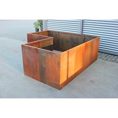 two metal planters sitting next to each other on the cement floor in front of a garage