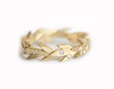 a gold ring with leaves and diamonds on it