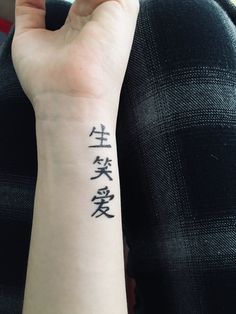 a person with a wrist tattoo that has chinese characters written on the back of their arm