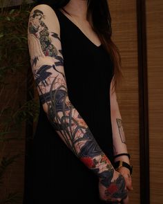 a woman with tattoos on her arm holding a cell phone