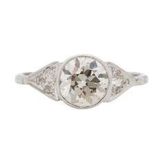 an antique style engagement ring with a round cut diamond in the center