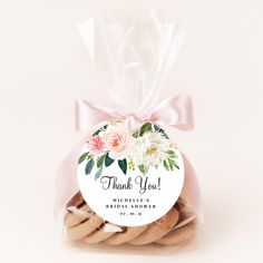 a bag filled with cookies covered in frosted icing and pink ribbon tied around it