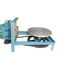 a machine that is sitting on top of a blue cart with a metal disc in it