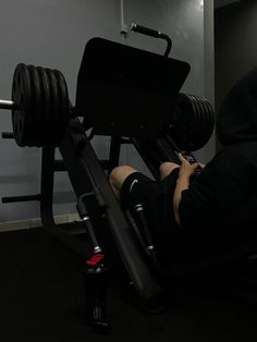 a man laying on top of a bench with a barbell in front of him