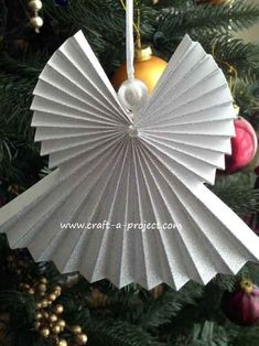 an ornament hanging from a christmas tree in the shape of a paper fan