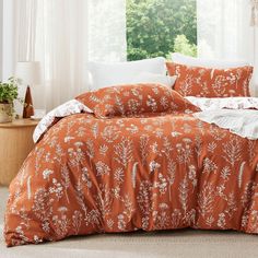 an orange comforter with white flowers on it