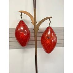 two red hanging objects on a wooden pole