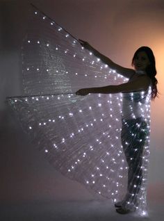 a woman in white dress with lights on her wings