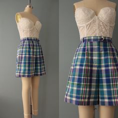 Vintage preppy summer tap shorts in blue green lilac pink plaid print. High banded waist with zipper/button closure. Made by Izod Fits like small: 28" waist 44" hips 18" length 14" inseam 6" rise Condition: excellent Vintage Plaid Bottoms For Summer, Vintage Plaid Summer Bottoms, Preppy High-waisted Shorts For Summer, Summer Preppy High-waisted Shorts, Plaid High-waisted Fitted Shorts, Fitted Plaid High-waisted Shorts, Plaid High Waist Cotton Shorts, High Waist Plaid Cotton Shorts, Preppy Fitted Cotton Shorts