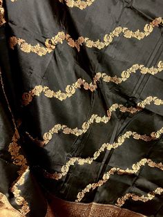 SILK MARK CERTIFIED !!!Black Color Pure Banarasi Katan Silk Dupatta with Muted Gold Zari. Item : DupattaBase Fabric : Pure Katan Silk Color : Black Silk Mark Certificate given with the Saree(Yes/No) : Yes Disclaimer -:- Color variation is possible due to various reasons like phone or desktop setting, resolution etc. Please don't hold us responsible. Our aim is to put the exact color of the Saree.- If the Saree is Pure Silk, we will put it very clearly in our listing that it is Pure Silk. If we d Black Silk Blouse Piece With Zari Work, Black Silk Fabric With Zari Embroidery, Black Silk Embroidered Saree Fabric, Black Art Silk Blouse Piece For Eid, Transitional Black Art Silk Blouse Piece, Black Art Silk Blouse Piece For Transitional Season, Black Silk Dupatta With Traditional Drape, Black Banarasi Silk Blouse Piece For Eid, Unstitched Black Silk Blouse Piece