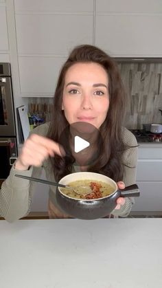 a woman holding a bowl of food in front of her face